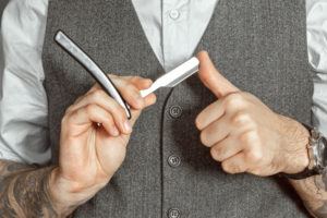 Rasur mit dem Rasiermesser: Mann klappt Rasiermesser auf